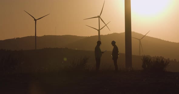 One Engineer Shows Another Engineer the Information on the Tablet. Sunset in the Background alt