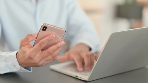 African Man with Laptop Using Smartphone Close Up alt