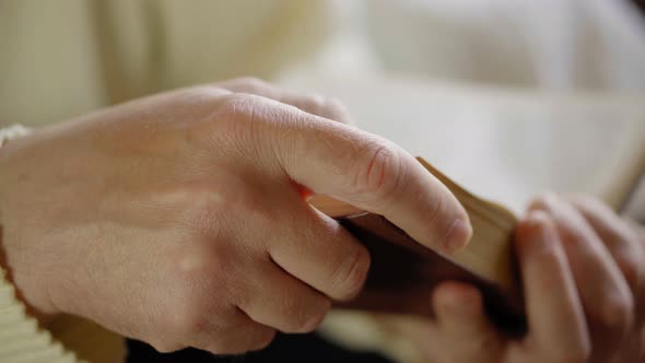 Man is Reading Old Book Closeup with Hands Side View alt