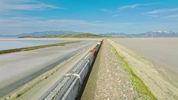 AERIAL - Train on railway, Great Salt Lake, Utah, forward tracking shot alt