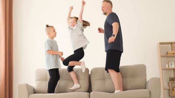 Dad Plays with the Children They Jump on the Couch alt