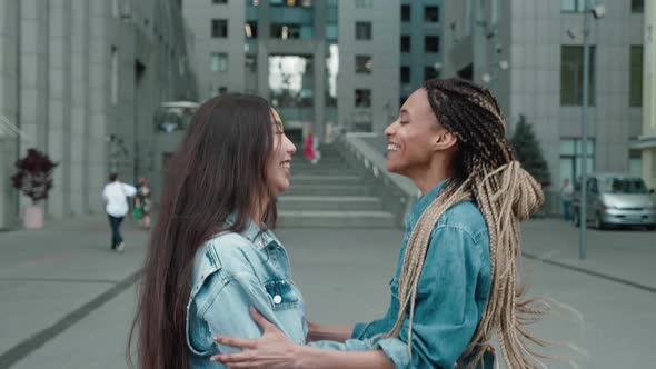 Two Friends Meet on a City Street and are Happy Together alt