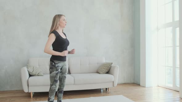 Disabled woman with prosthetic leg does an exercise engaged in squatting.