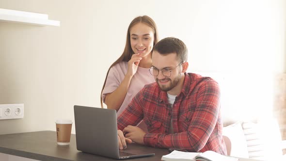 Happy Charming Lady Stands Behind Back of Pleasant Husband, Closes Eyes with Pleasure