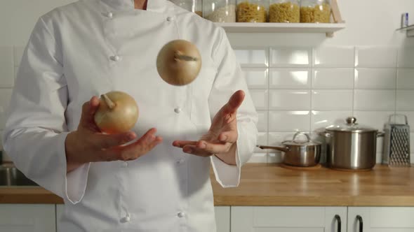 Chief-Cooker Juggles An Onions In A Kitchen