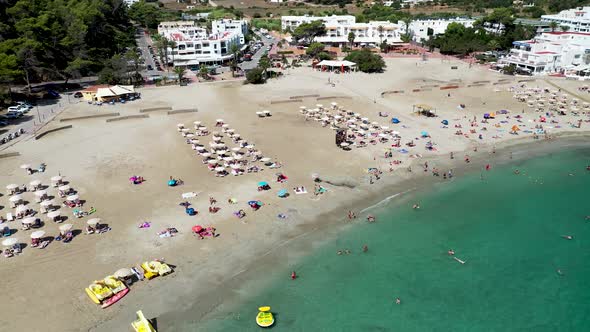 Aerial footage of the Spanish island of Ibiza showing the beautiful beach front alt