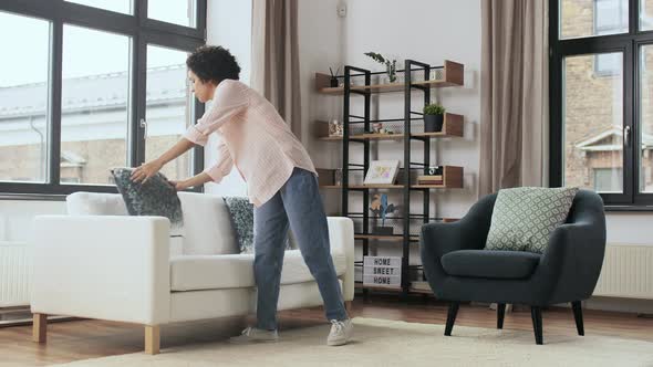 Woman Arranging Cushions at Home