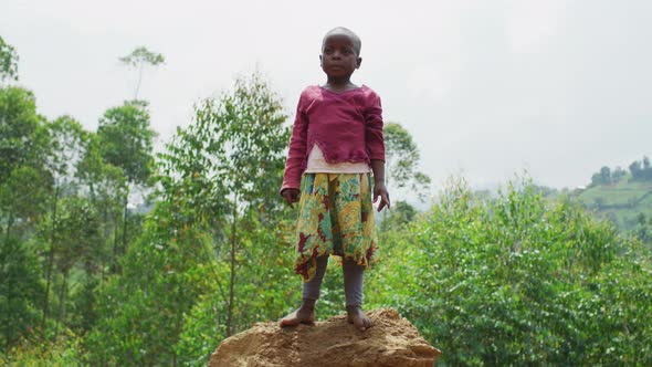 African child standing on a mound alt