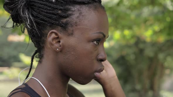 young beautiful concentrated African athlete wearing headphones before running alt