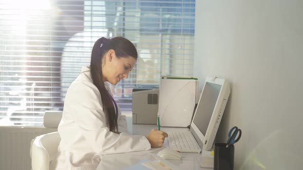 Female Doctor Using Pc Computer While Sitting at Work Place