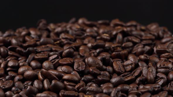 roasted coffee beans rotating, seeds of coffee on black background