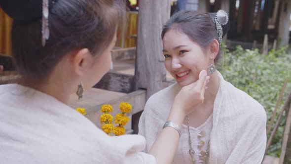 Two Teenage Girls In Thai Traditional Dress Applying Make Up alt