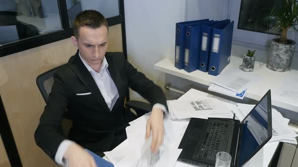A Successful Manager Working With Papers and Laptop In Office. Young Businessman At Work. 