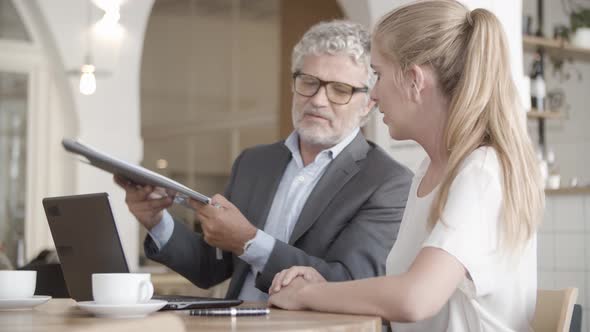 Focused Caucasian Businessman Holding Clipboard and Showing alt