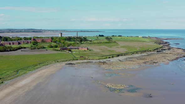 Old brick Quay buildings, the Portrane Round Tower, and Irish landscape. alt