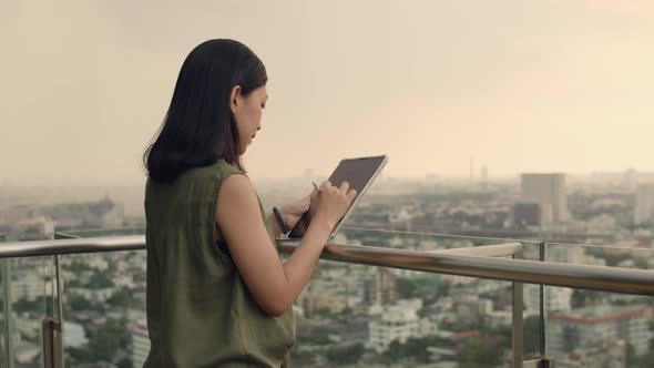 Asian female using tablet chatting with friends.