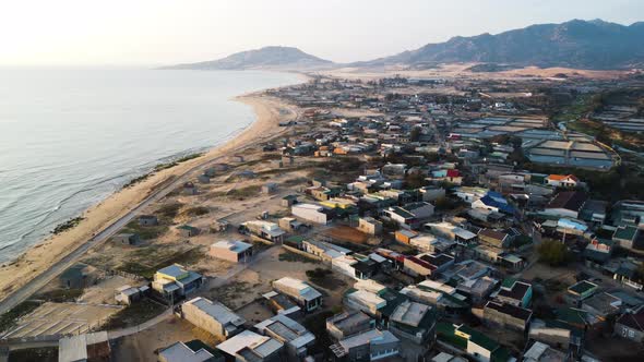 Sea and Son Hai quiet coastal town in morning sunlight aerial view, Vietnam alt