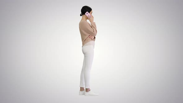 Emotional Smiling Young Woman Talking on the Phone and Gesturing on Gradient Background alt