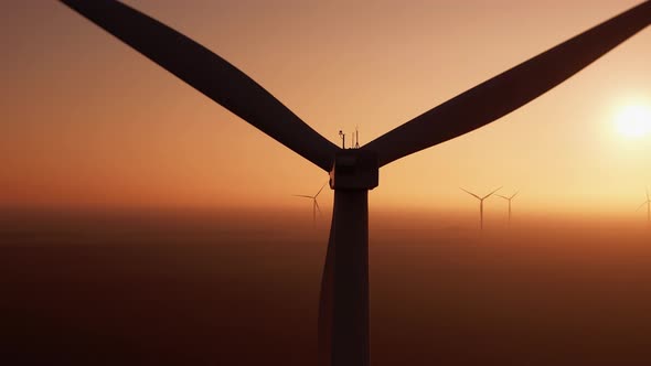 Wind Turbine with Powerful Propeller Rotates at Sunset