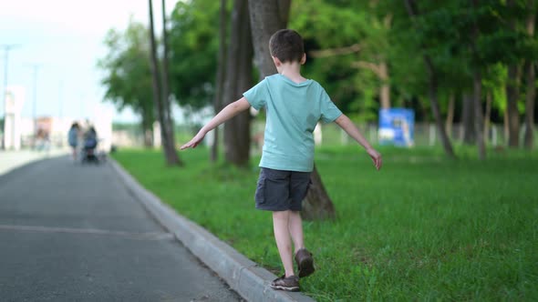 Boy Walks on the Road Curb