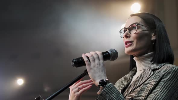 The Female Financial Coach Emotional Gesturing Talks From the Stage with Spectators at Forum. Too alt