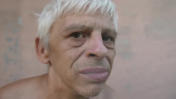 Distrustful Man Looks at Camera and Smoking alt