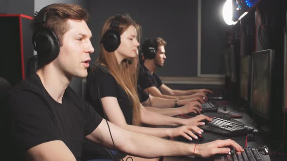 Group of Concentrated People in Headphones Enjoying Online Video Game on Computers of Gaming Centre alt