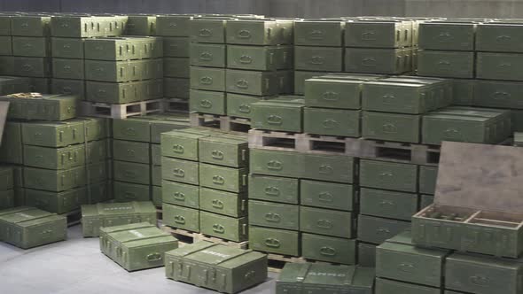 Huge stack of ammo boxes with RPG missiles and rifle ammunition in warehouse. alt