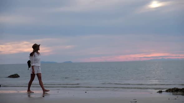 A woman strolling on the beach by the sea