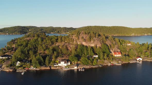 Beautiful Norwegian island fishing village cabins at sunset, aerial panoramic alt