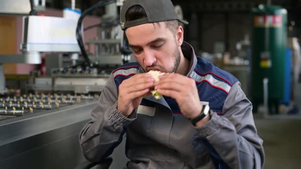 A young man takes food at workplace during work hours or during his lunch break alt