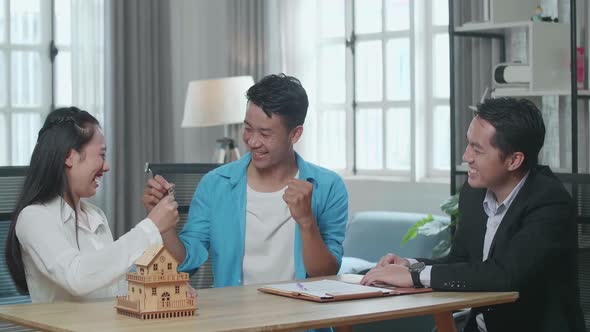 Asian Couple Receives The Keys From A Real Estate Agent Then Celebrates alt