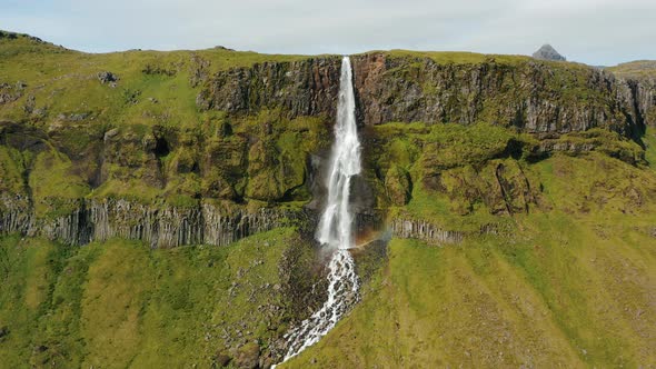 Aerial Drone Footage of Bjarnarfoss Waterfall with Its Green Cliffs in Western Iceland alt
