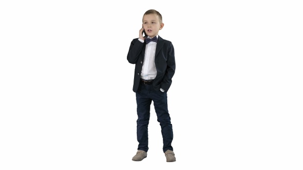 Cute little boy talking on his smartphone and standing alt