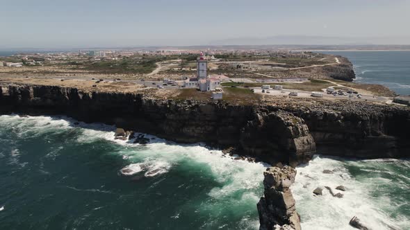 Nau dos Corvos or Ship of Crows and lighthouse, Carvoeiro cape, Peniche in Portugal. Aerial forward