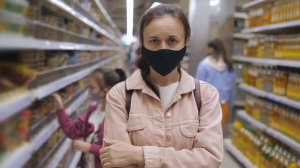 Woman in Protective Medical Mask Black in the Supermarket During the Outbreak of Coronavirus
