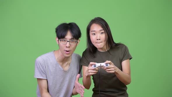 Young Asian Couple Playing Games Together