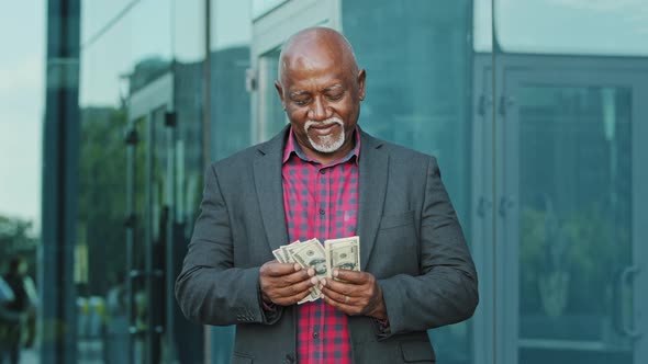 Mature Man with Pile of Dollars Counting Paper Banknotes alt