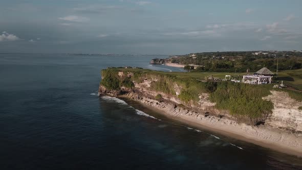 Aerial Footage of the Beach and a Big Cliff with a Wedding on Top of It