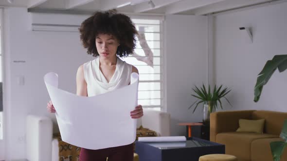 Mixed race woman looking at design in creative office alt