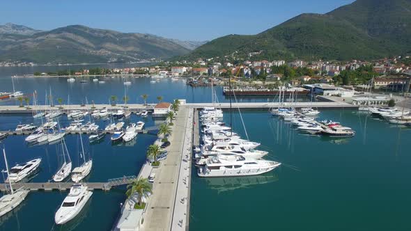 Flying Over Porto Montenegro Luxury Marina Pier With White Yachts alt