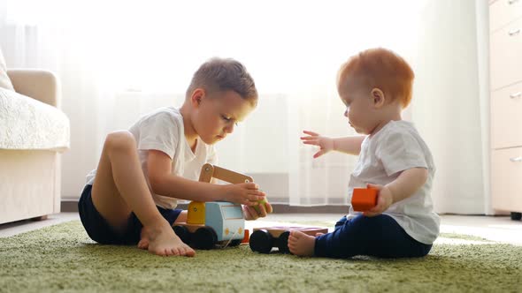 Boy and Girl Are Playing with Toy Car on a Floor