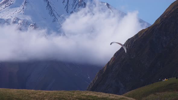 Parachutist paragliding in the mountains alt