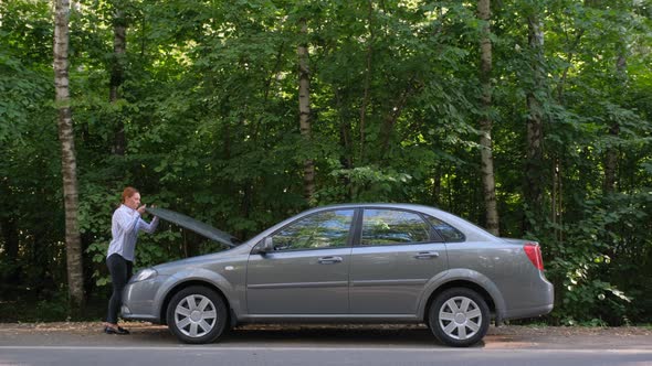 Side View of Confident Woman Opening Car Hood and Looking at Engine.  alt
