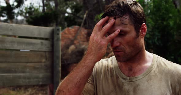 Tired military soldier standing at boot camp alt