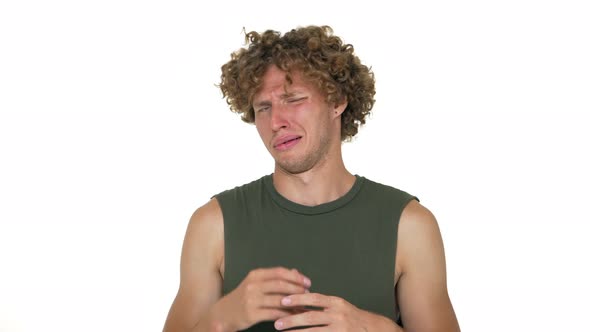 Caucasian Curly Guy Isolated Over White Background Waving Hand Under Nose with Disgust on His Face alt