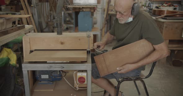 Carpenter measuring a wooden plank
