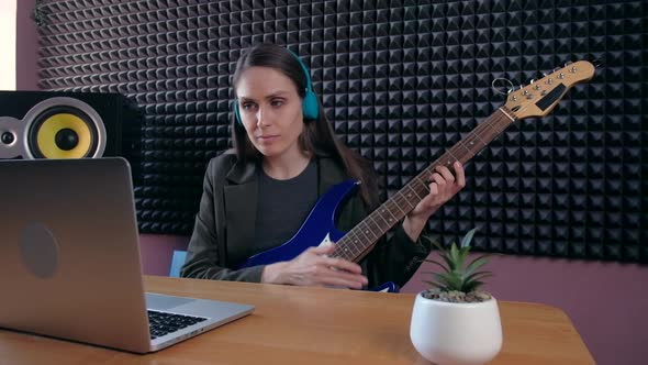 Female Learning Play Guitar at Home Using Online Lessons alt