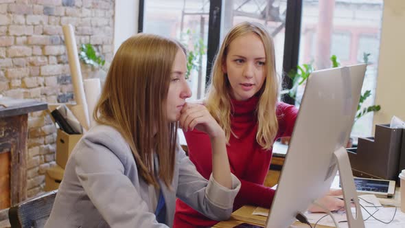 Smiling Female Designers Discussing Project on Computer