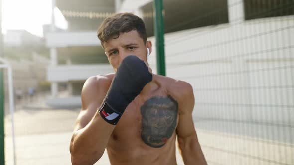 Boxer Practicing Punches in Front Camera Outdoors alt